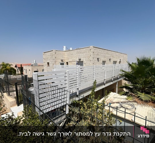 גדר עץ לבנה עם צמחייה מסביב